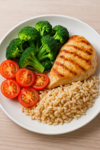 It's a plate of chicken, rice, tomatoes, and broccoli