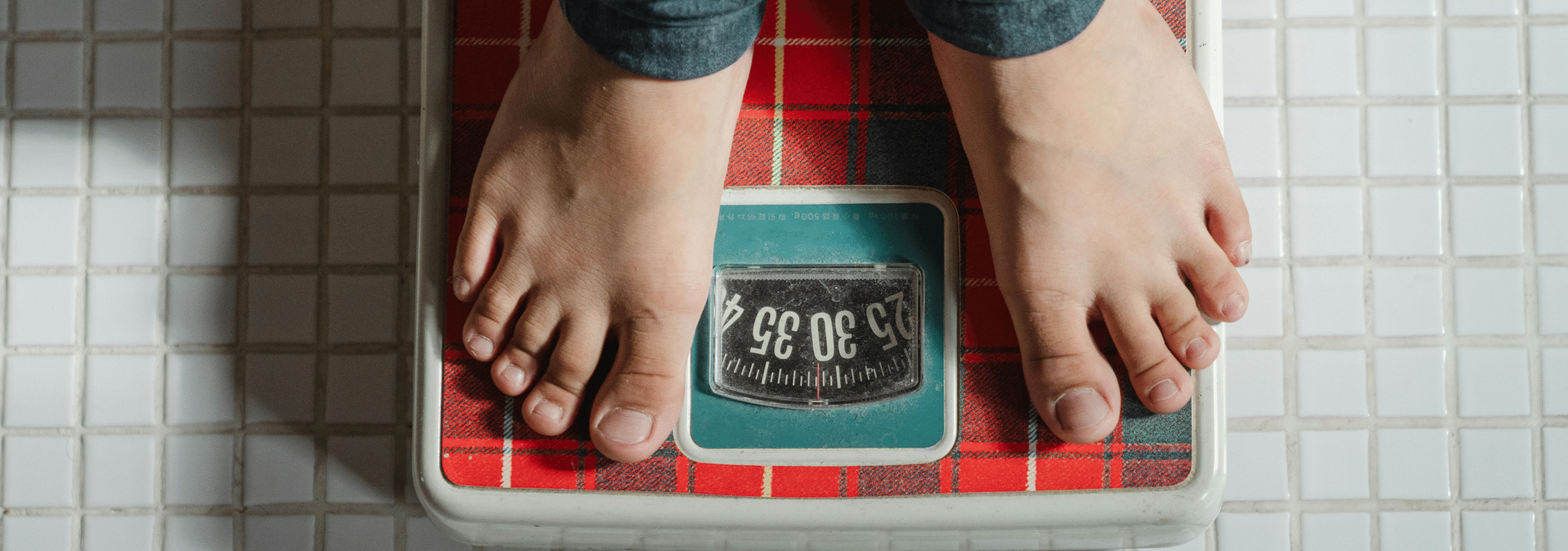 The image is of a pair of feet standing on a weight-scale.