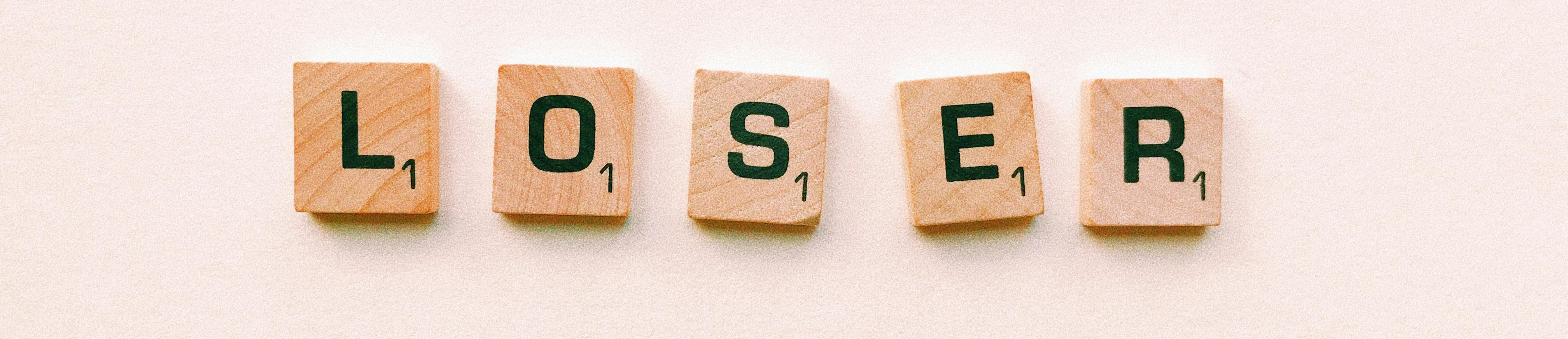 Scrabble tiles spelling “LOSER,” symbolizing The Biggest Loser weight loss study and metabolism debate.